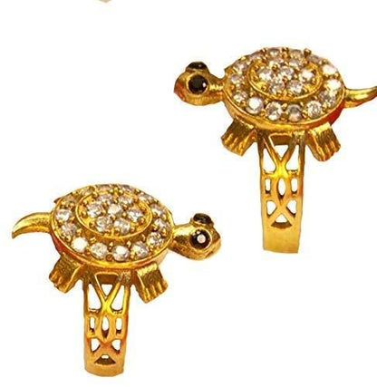 Two gold turtle-shaped pendants with embedded stones on a white background