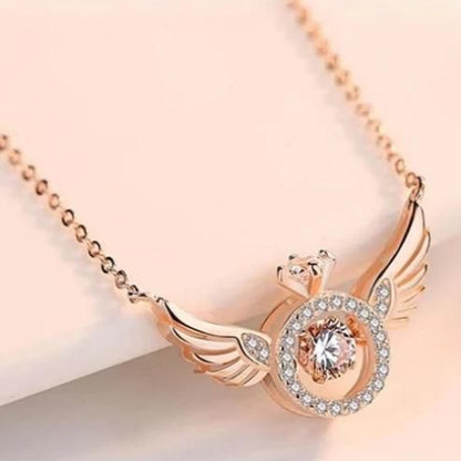 Rose gold necklace with angel wing design on a light background